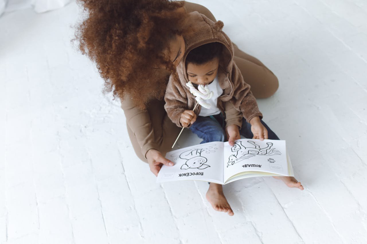 African American mother and young child reading a picture book together, fostering bonding and learning.
