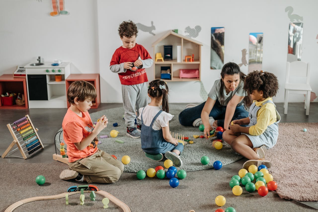 Young children and a teacher engaging in play and learning activities in a preschool setting.